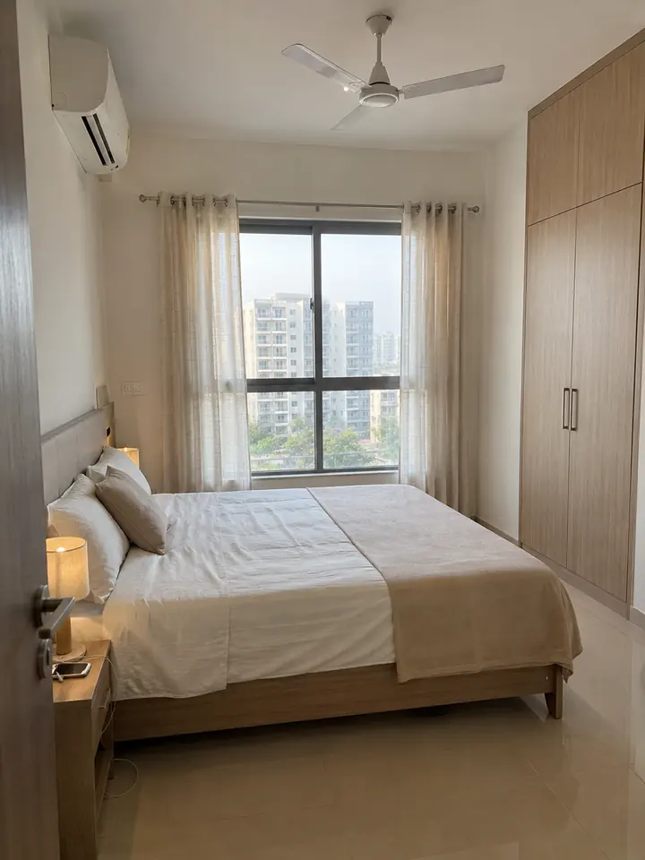 Rental-ready second bedroom in a Hyderabad 2 BHK with a queen bed, built-in wardrobe and split AC