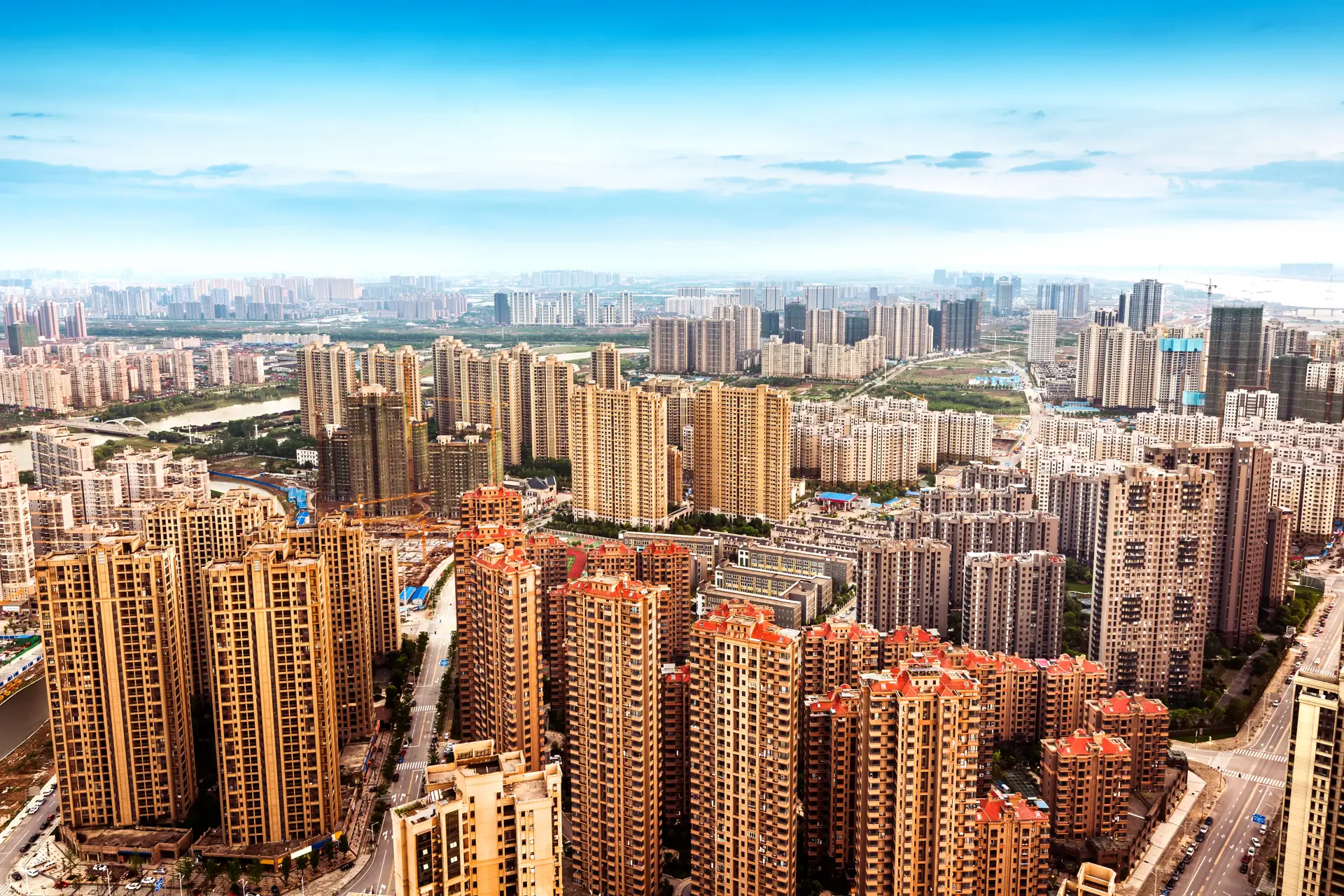 Aerial view of gated community high-rise apartment buildings under a hazy city skyline