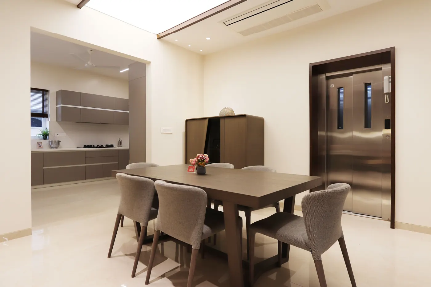 Dining area opening into a fitted modular kitchen in a ready to move 4 BHK flat in Hyderabad